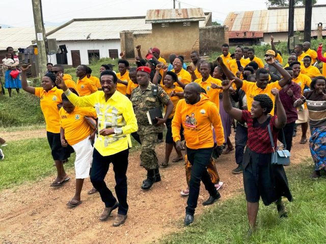 Minister Muhwezi in yellow shirt being welcomed by a team of his supports to Nyakagyeme sub- county head quaters where he held community baraza meeting on addressing gaps in service delivery. photo by RK